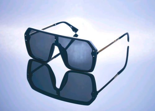Black sunglasses with a reflective surface on a light blue background